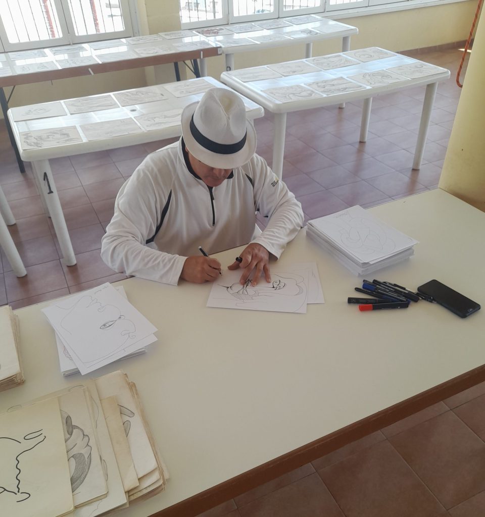 Muestra ha Vicjes Gonród firmando obras de arte en su estudio.